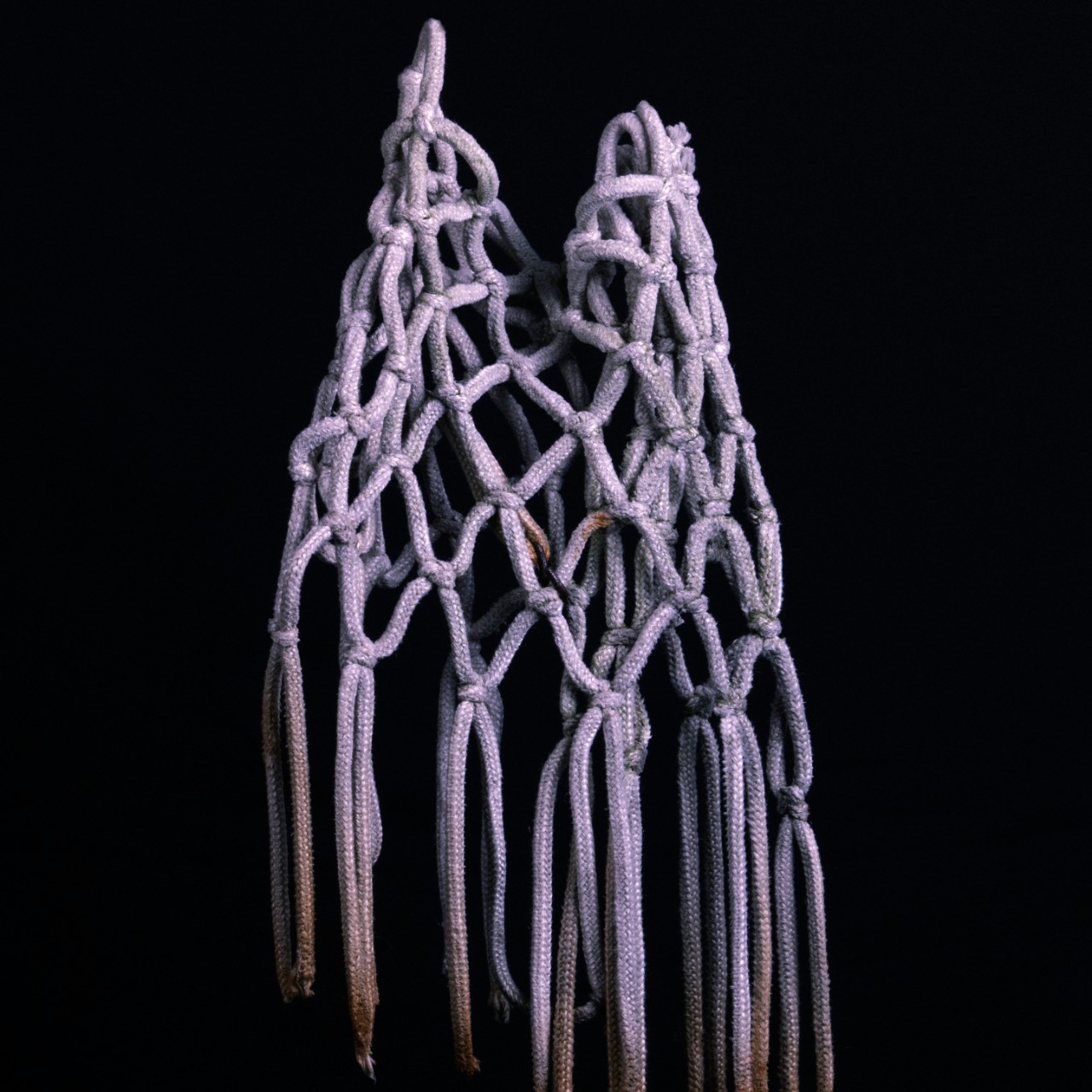 rope net hanging against black wall