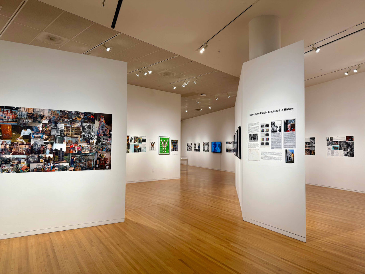 Overview of gallery entrance featuring wall texts and large photo collage from Nam June Paik in Cincinnati: A History exhibition