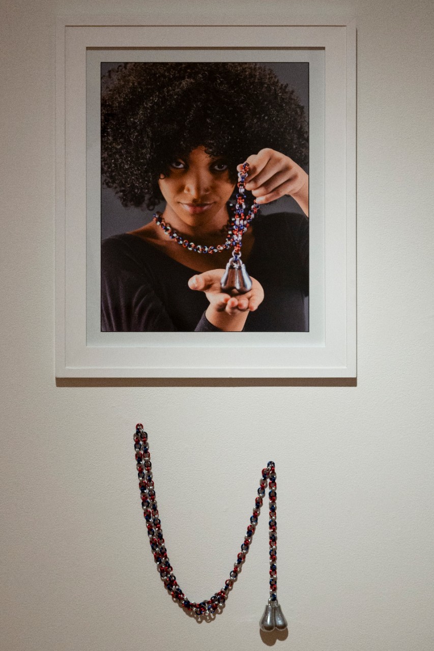 female portrait holding chained porcelain and aluminum balls