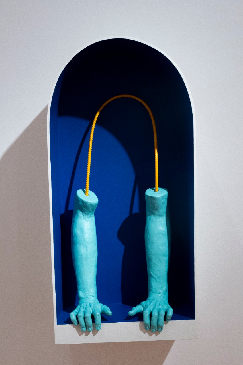 blue ceramic arms and hands inside blue shelving