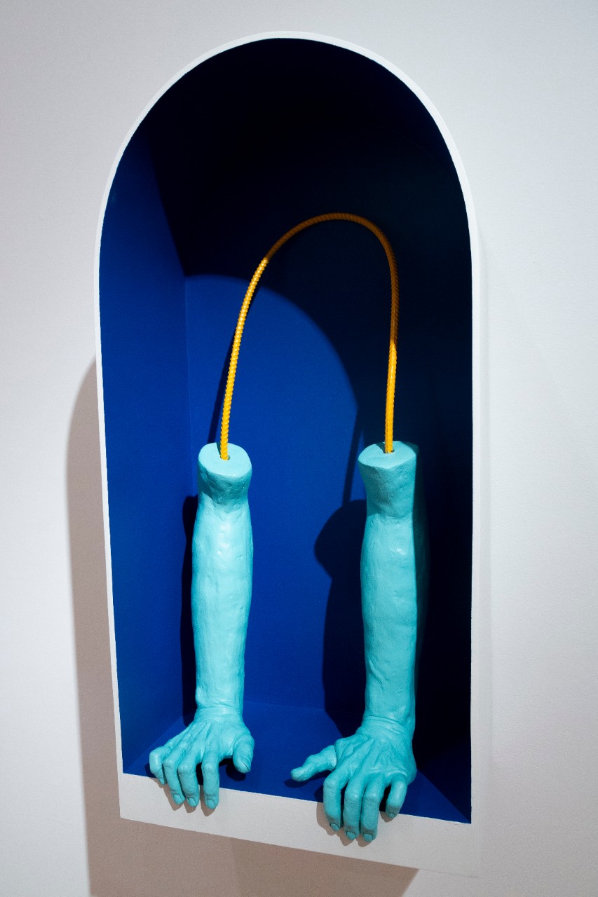 blue ceramic arms and hands inside blue shelving