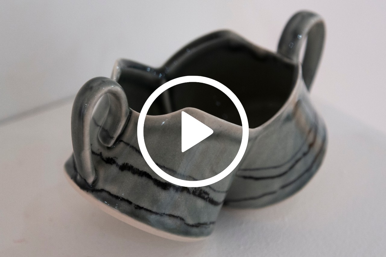 fused gray ceramic mugs with video icon overlayed