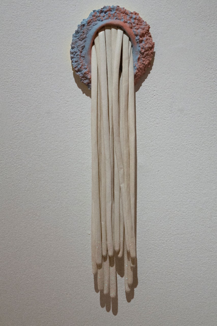 stretched white latex extending from blue-pink opening