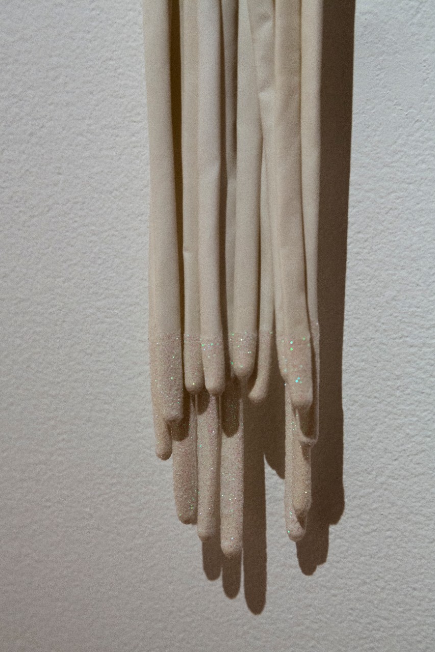 stretched white latex extending from blue-pink opening